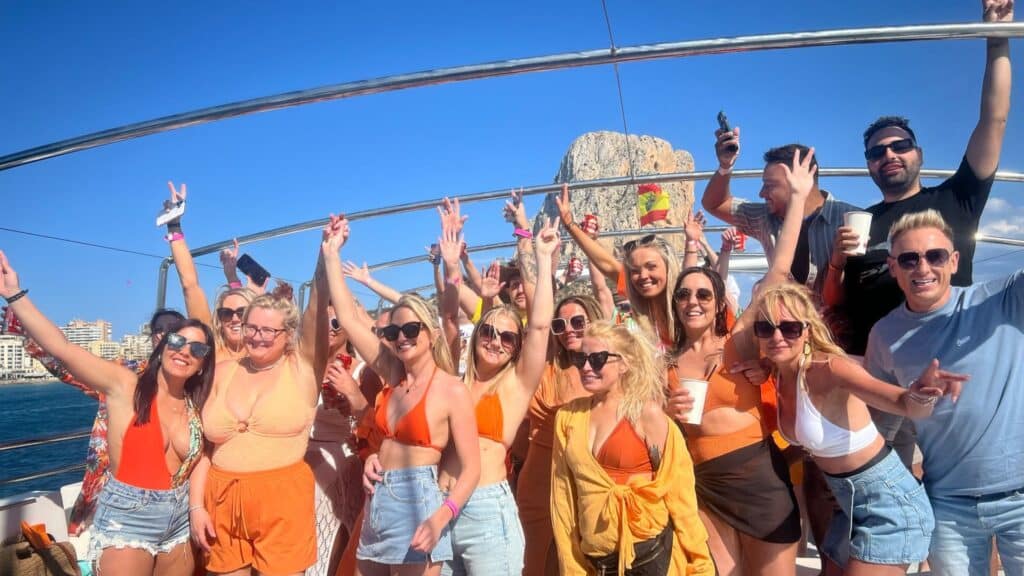 Group with hands in the air on a boat party in Benidorm